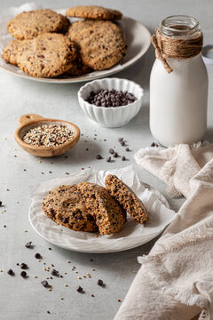 Homemade quinoa cookies on a plate served with milk and messy ingredients.
