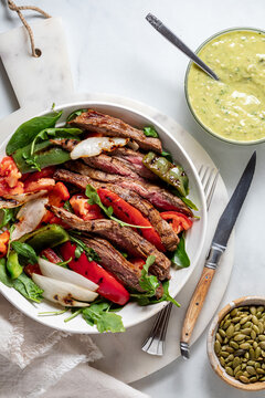 A freshly made fajita steak bowl served with avocado cilantro dressing.
