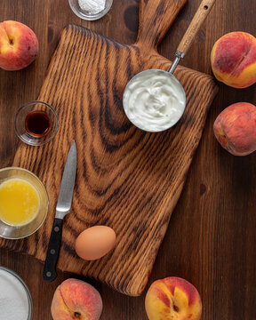 Above view of ingredients on and around a wooden cutting board for baking a cake