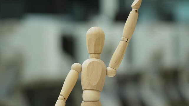 Wooden mannequin figure standing in office, business concept