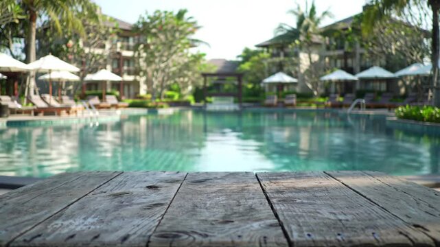 Empty Wooden Table Overlooking a Tropical Swimming Pool at a Resort