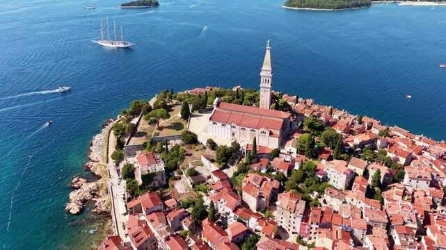 Aerial drone view of the church of St Euphemia on the tip of the peninsula with boats on the sea around it, Rovinj, Croatia
