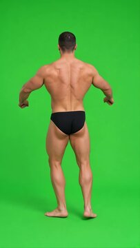 Muscular Young Male Bodybuilder Posing Shirtless on Green Screen