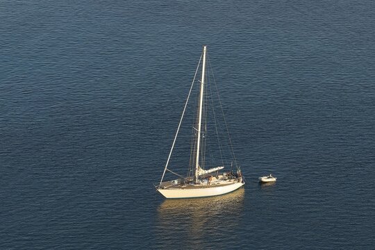 A lonely sailboat floats quietly on the vast sea, Navarino Bay, Pylos, Peloponnese, Greece