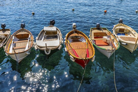 Colourful fishing boats reflected in the glittering water in the harbour of Manarola, Manarola, Cinque Terre, Ligurian Coast, Liguria, Italy