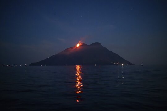 Volcano with eruption and lava flow reflecting on sea surface, Stromboli volcano, Stromboli, Aeolian or Lipari islands, Tyrrhenian Sea, Sicily, southern Italy, Italy