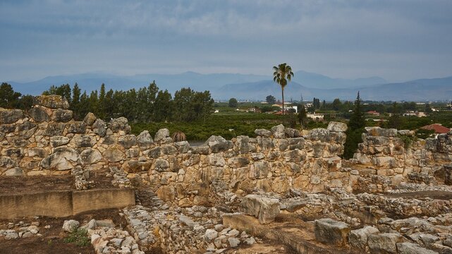 Stone walls and ruins in a green landscape against a cloudy sky, Tiryns, ancient city in Argolis, Mycenaean, Peloponnese, Greece