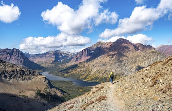 Hikers on the trail to Scenic Point, view of Two Medicine Lake with mountain peak Rising Wolf Mountain, Glacier National Park, Montana, USA
