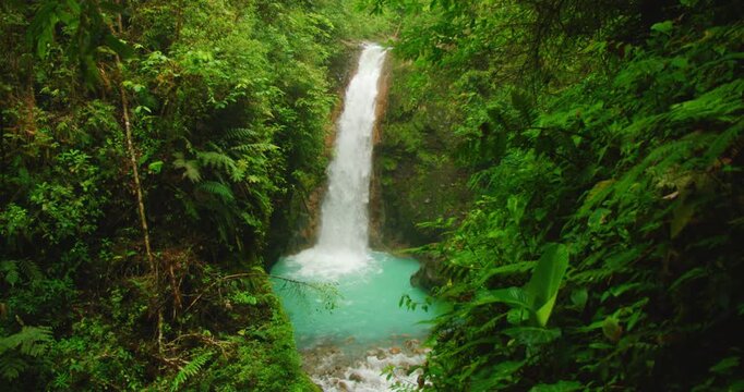 Scenic la Pintada waterfall plunging into turquoise pool in Costa Rica Blue Falls area amid lush rainforest