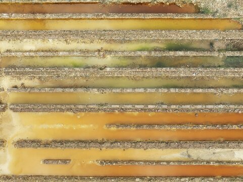 Abandoned saline ponds in the mineral-rich area of the Rio Tinto mines, hence the different colours caused by oxidised iron minerals. Aerial view. Drone shot. Huelva province, Andalusia, Spain