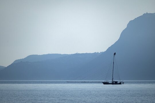 Felcua, Ferdilux or felucca with a tall mast, long gangplanks and a lookout platform for several people, a lookout boat, specially designed for hunting swordfish (Xiphias gladius), Strait of Messina, with Sicily in the background, Italy