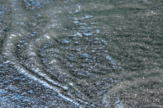 heavy rain floods a city street with streams of rainwater.