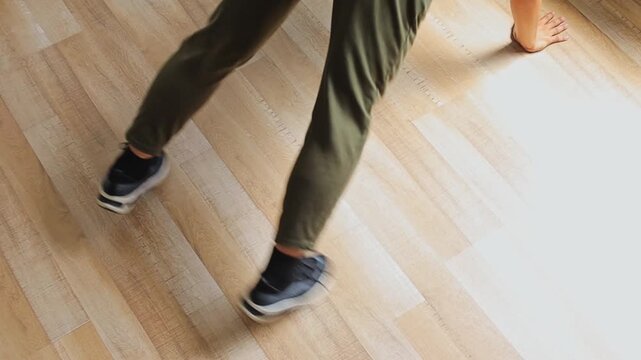 Close-up on legs and feet executing plank jacks core workout for cardio training inside room