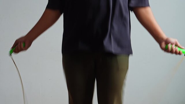 Close up Fitness enthusiast doing skip rope cardio exercise routine at home