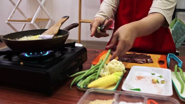 Chef preparing fresh green beans while fries cook in hot pan nearby