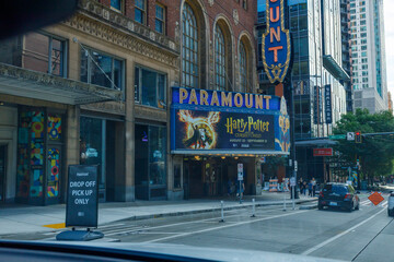 Fototapeta premium The Paramount Theatre marquee advertises Harry Potter and the Cursed Child, running August 22 to September 12, its vertical blade sign glowing above a downtown street.
