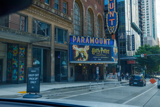 The Paramount Theatre marquee advertises Harry Potter and the Cursed Child, running August 22 to September 12, its vertical blade sign glowing above a downtown street.