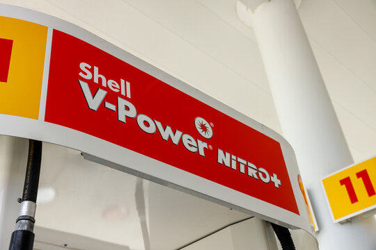 A close view of the red Shell V Power Nitro Plus sign mounted on a white pump canopy, a fuel hose and pump number 11 sign visible below at a Federal Way gas station.