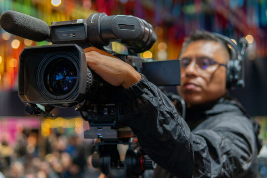Cameraman recording live event with professional video camera