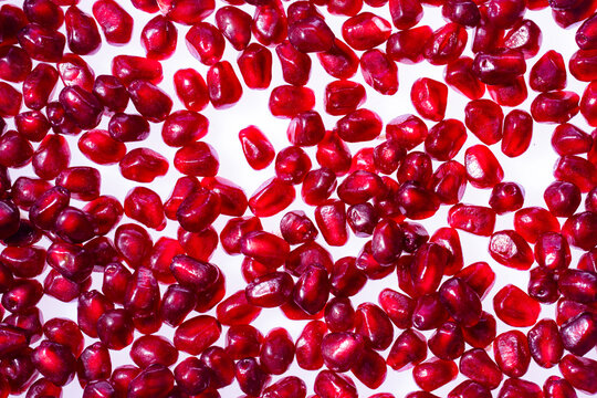 Red ruby pomegranate arils closeup pattern. Rube juicy pomegranate background. Pomegranate seeds macro texture. Pomegranate arils pattern.
