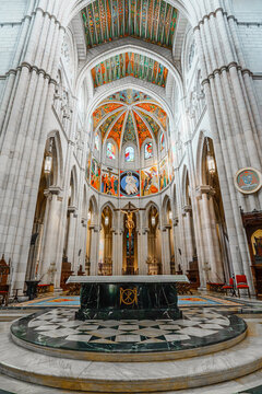 Illuminated apse with painted dome and crucifix in Almudena Cathedral, Madrid