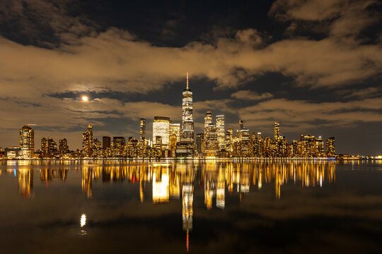 NYC night cityscape. NYC skyline night. New York City downtown night skyline. NYC glowing city night.
