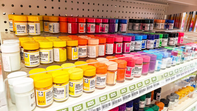 Row of colorful glass poster paint bottles display: A vibrant array of art supplies, including paints, brushes, neatly arranged on shelves in a retail store. Thailand, September 8, 2026