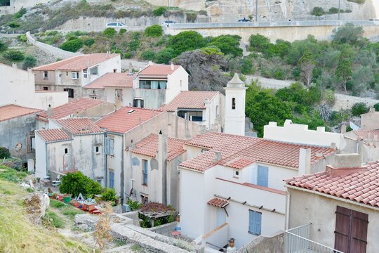 peaceful village rooftops in hilly landscape with buildings and vegetation from aerial view. architecture and real estate scene with beige and red tones. serene and detailed aerial shot ofa.