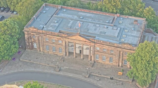 York Castle Museum former Female Prison features a Georgian brick facade, central portico, columns and pediment beside Clifford's Tower, York, North Yorkshire, England, drone descent