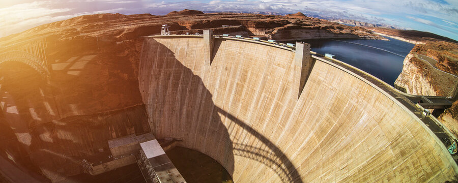 Massive Concrete Dam Stands Tall Against a Vast Landscape With Blue Sky and Clouds