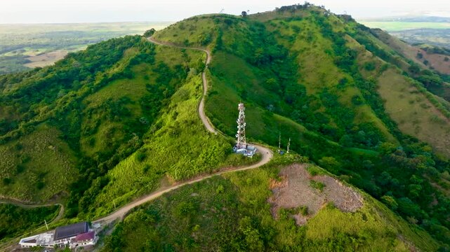 Aerial view of a winding mountain road in the Dominican Republic - drone video. Aerial view of a mountain switchback. Gravel country road in the mountains. Foothill scenery in summer.