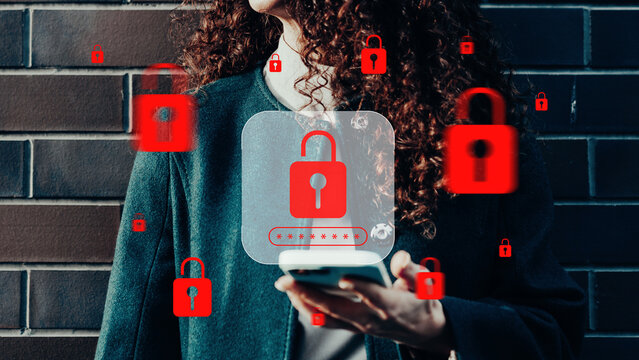 Person holding a mobile phone with digital security locks in a city setting on a weekday