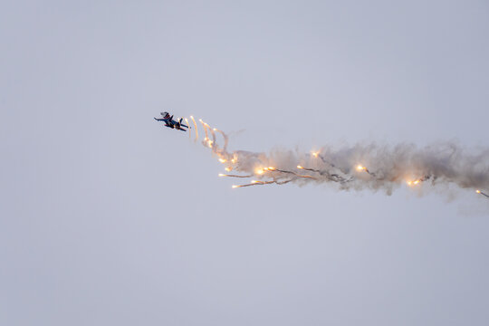 an aviation show in the sky. Modern jet fighter shooting fire flares rockets with sparks. Airplane deploying . fire protection IRCM. traps for air defense missiles