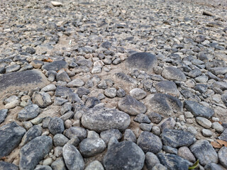 Low angle view of gravel pebbles and small stones on ground. Natural gravelly texture background for construction and landscaping. © Setyotuhu