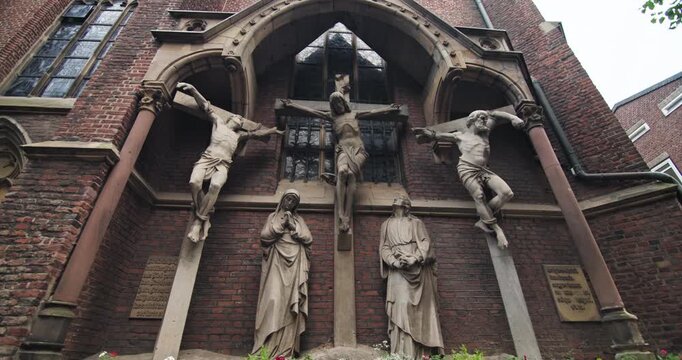 Crucifix Saint Lambert Basilica Dusseldorf Germany historic cityscape shows a religious figure on the church wall surrounded by historic architecture in a European tourist city.