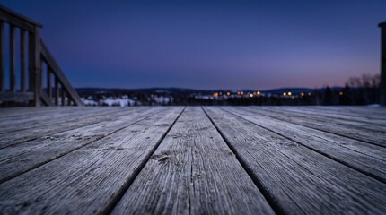 Obraz premium Empty wooden deck with weathered planks at twilight overlooking a blurred city horizon, peaceful evening atmosphere and blue hour serenity for product placement and real estate marketing.
