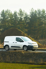 Unbranded delivery van driving past farmland © AlexGo