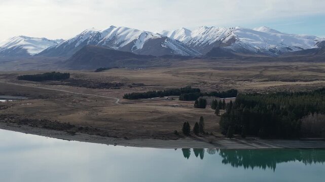 Lake Pukaki aerial view showcases New Zealand nature with stunning Southern Alps mountains, snow covered peaks and blue water surrounded by beautiful scenic landscapes for tourism