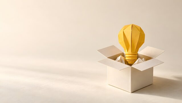 Gelbe Papiergl&uuml;hbirne in offener Box als Symbol f&uuml;r Gesch&auml;ftsidee und Startup