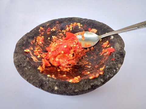 Indonesian spicy chili sambal served on a traditional stone mortar.