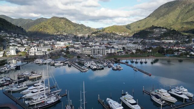Queen Charlotte Sound aerial view reveals Picton New Zealand with yachts ships and ferries at busy docks surrounded by beautiful coastal urban scenery for travel tourism