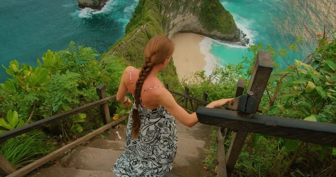 Woman walking down to tropical Kelingking Beach on Nusa Penida Bali