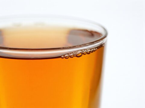 Close-up of whiskey glass with amber liquid and bubbles for beverage advertising