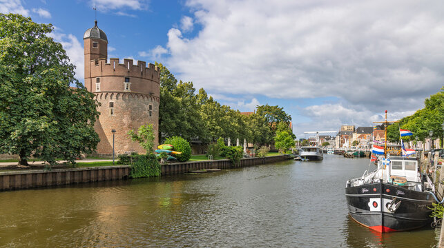 Zwolle, Netherlands - The medieval Pelsertoren tower on the old city wall along the canal, featuring a traditional Dutch ship moored on a summer day.