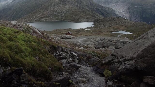 Idyllischer Bergbach in den Schweizer Alpen mit Blick zum Bergsee - Schweizer Bergp&auml;sse Grimsel Pass Berner Oberland
