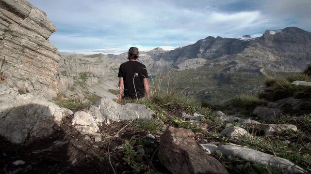 Mann von hinten beim Wandern und Bergpanorama geniessen mit Ausblick auf die Urner Bergwelt im Sommer - Klausenpass