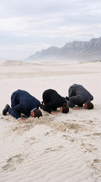 Business People Burying Their Heads in Sand as Avoidance Concept