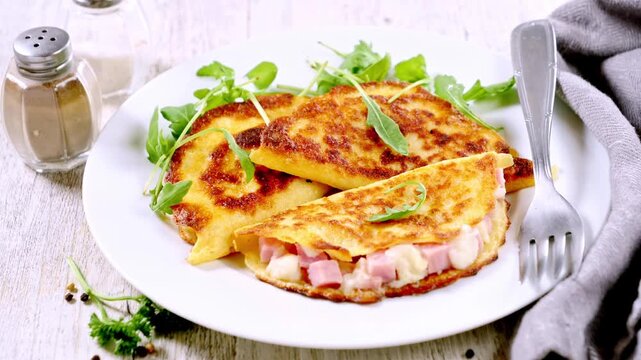 Savory Crepes Stuffed with Diced Ham and Melted Cheese Served on Plate
