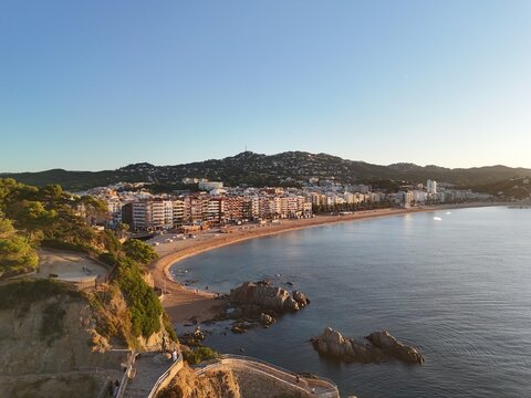 Aerial view taken from a drone of the coast of Lloret de Mar, Costa Brava, Spain, early in the morning at sunrise - the sea, beach and coastal hotels