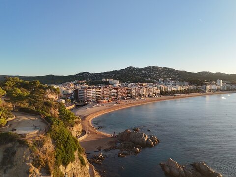 Aerial view taken from a drone of the coast of Lloret de Mar, Costa Brava, Spain, early in the morning at sunrise - the sea, beach and coastal hotels